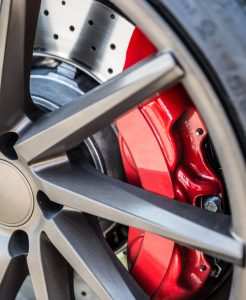 Red painted brake caliper close up inside a wheel