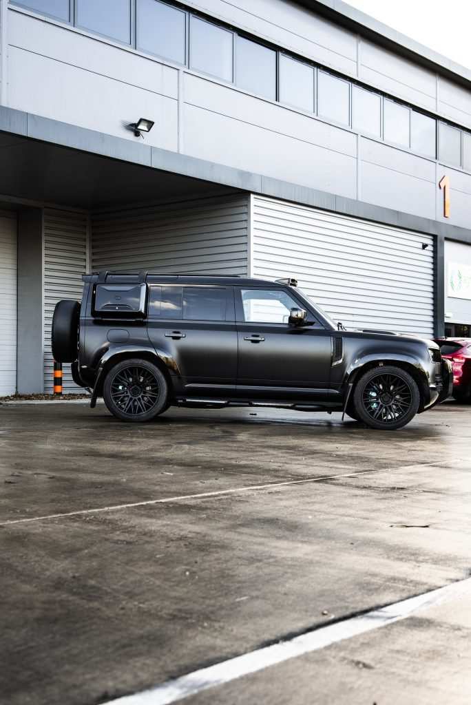 black defender full view parked outside garage