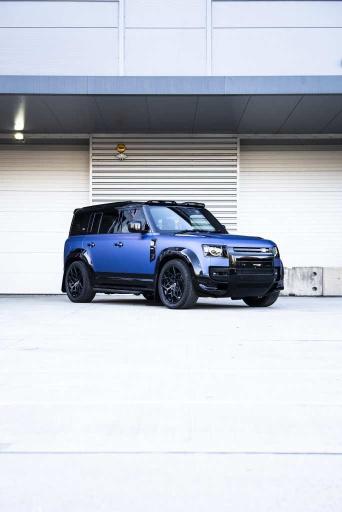 Defender 110 full view parked outside garage